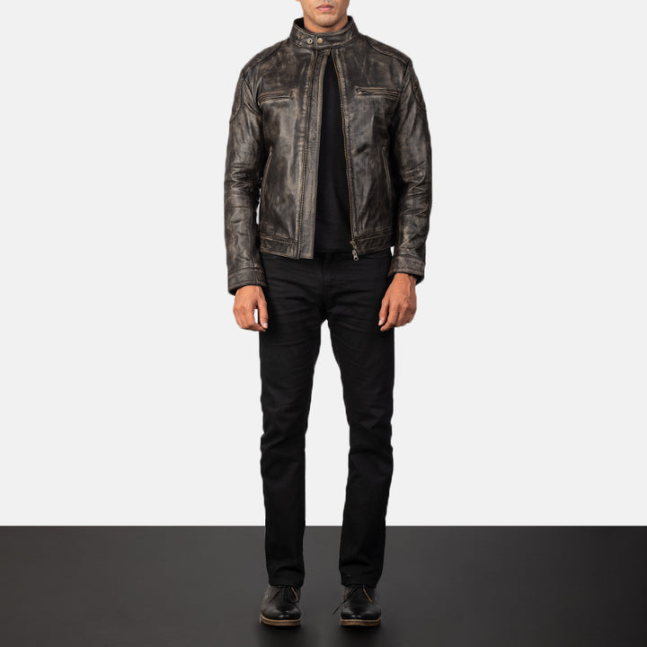 Person wearing a dark leather jacket and black pants on a white background